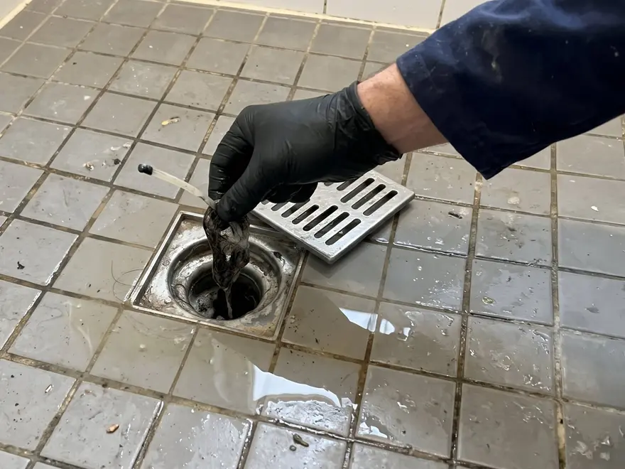 Débouchage Rueil-Malmaison (92500) : bonde de douche débouchée à la main gantée, cheveux retirés (illustration)